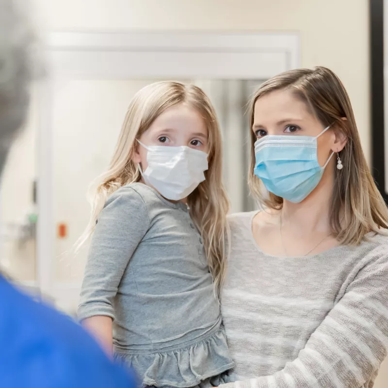 A mother and daughter wearing masks.