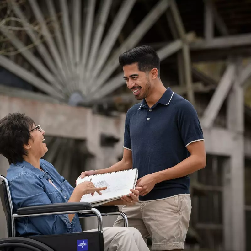 Woman in a wheelchair with her caregiver