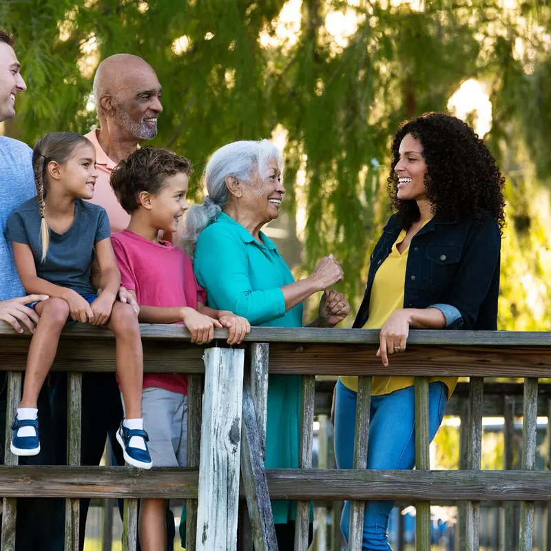 A Hispanic Family Chats on a Bridge in a Park