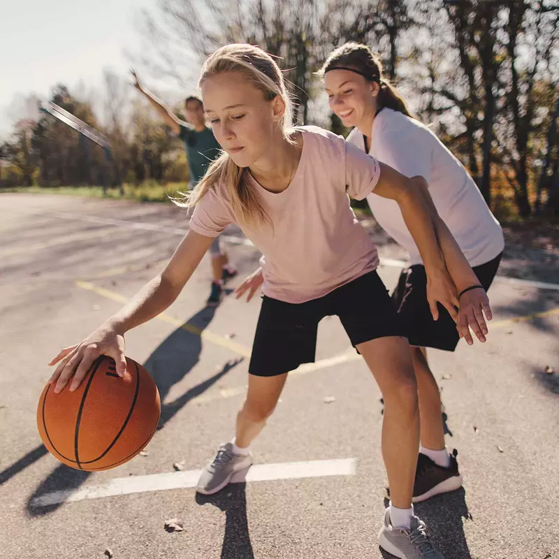 Young Girl Plays Basketball with Her Family