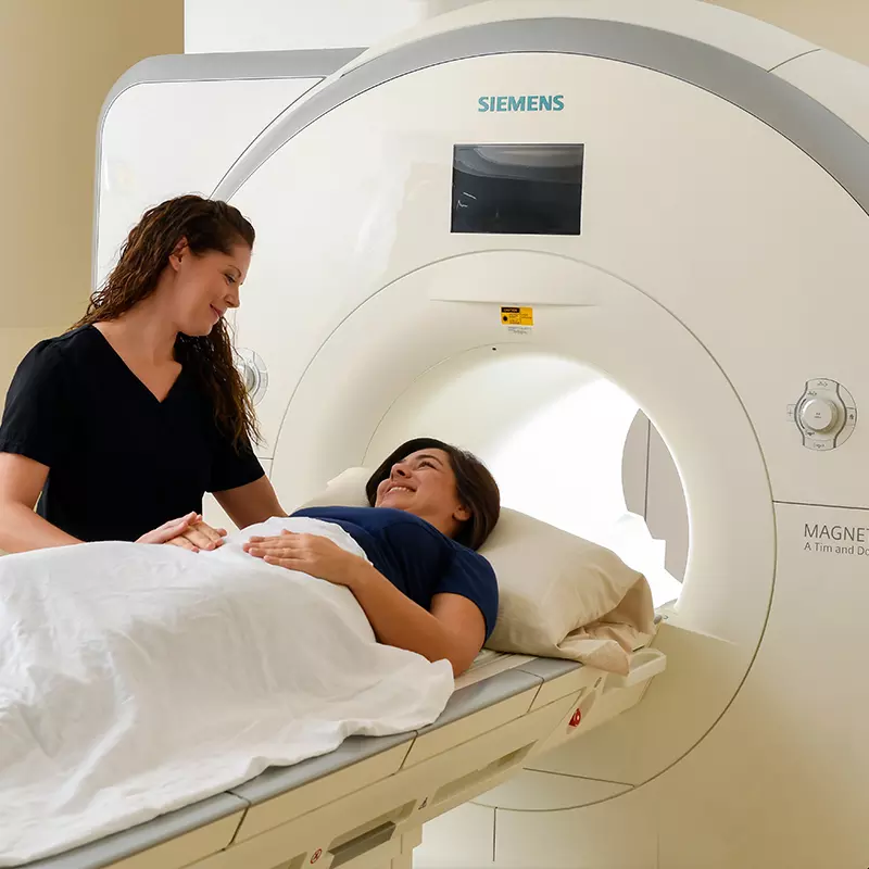 Woman inside imaging machine for care