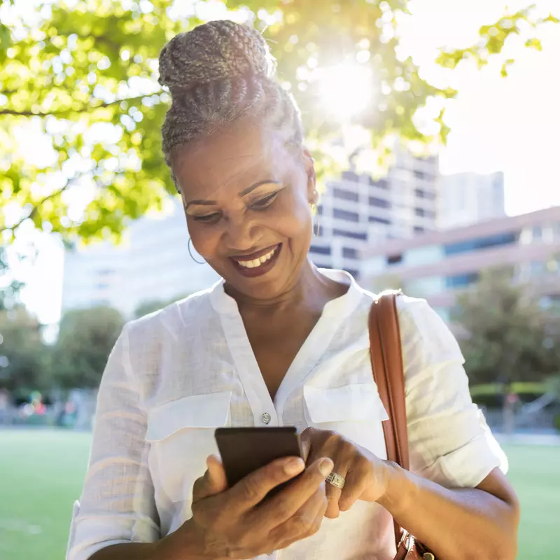 Woman using her phone while at a park.