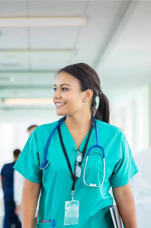 Female health care professional walking down hospital hallway