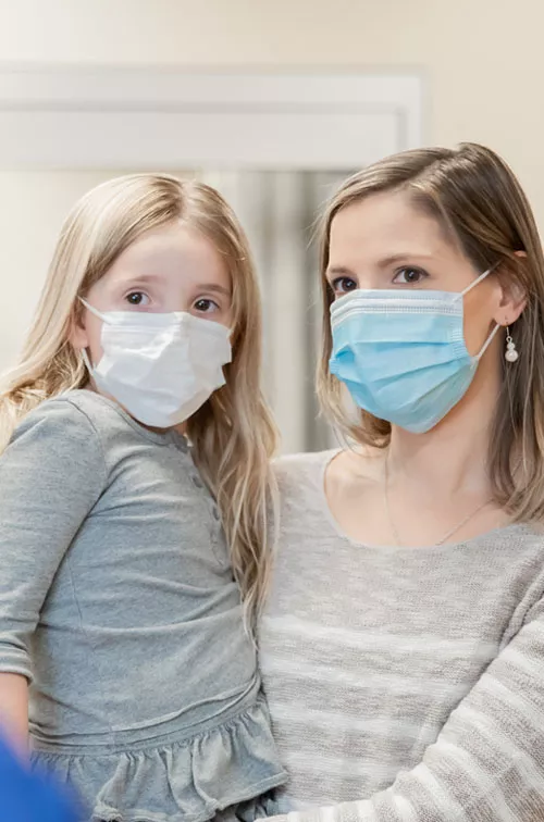 A mother and daughter wearing masks.
